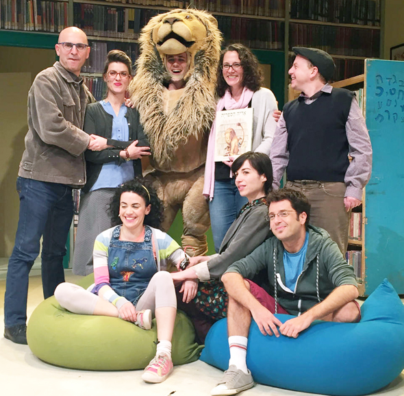 מישל קנודסן אוחזת בספר “אריה הספריה" בעברית עם צוות ההצגה בישראל