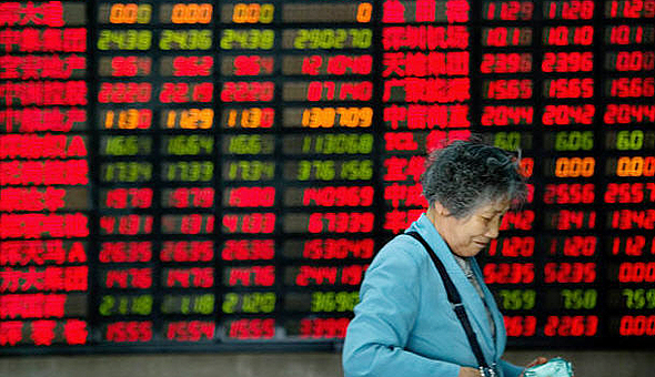 אישה סינית על רקע מסך בבורסה. הדעות חלוקות לגבי מי צריך לנהל את ענייני הכסף במשפחה