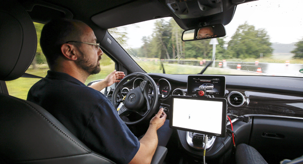 A driver lets go of the steering wheel in an autonomous vehicle experiment. Photo: Bloomberg