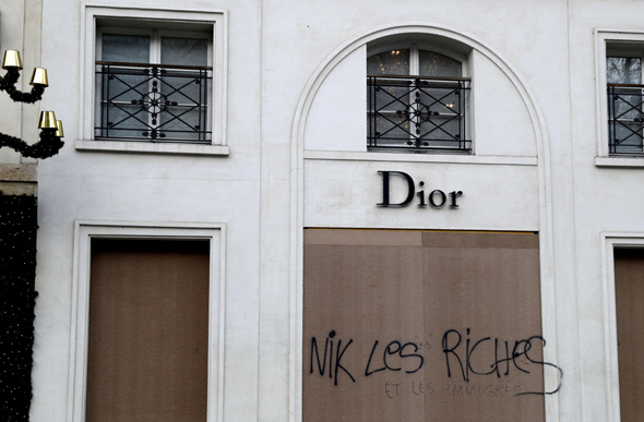 חנות של דיור בפריז ועליה הכתובת "דיפקו את העשירים ואת המהגרים"