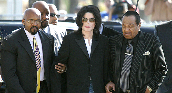 מייקל ג'קסון מלווה באביו ובשומר ראש בדרך לבית המשפט