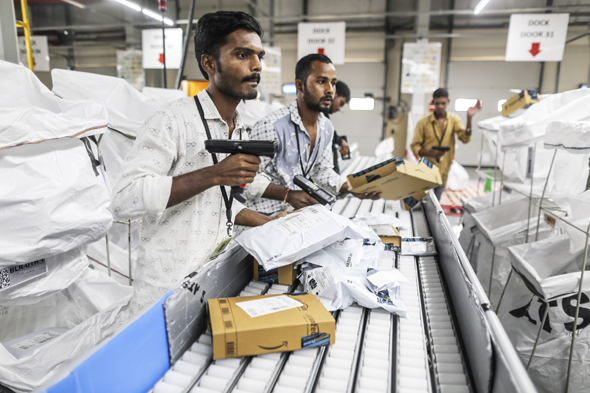 עובדי מרכז השילוח של אמזון בהיידראבד, הודו סורקים חבילות