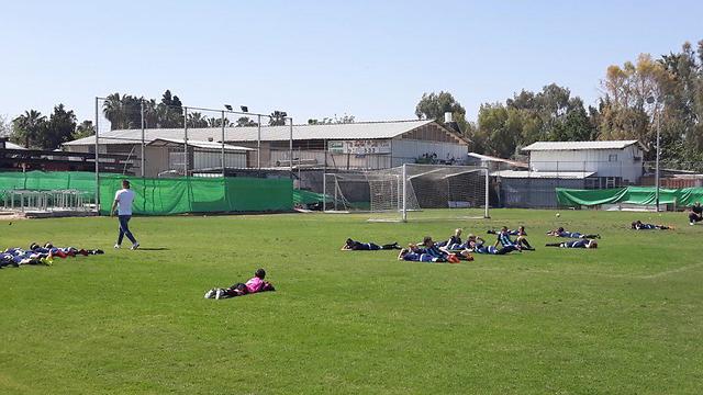 ילדים שוכבים על הדשא במשחק כדורגל