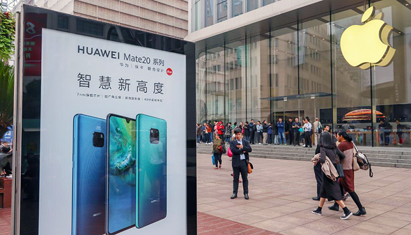 שלט של חברת ה סלולר וואווי מול חנות של אפל ב סין, צילום: גטי אימג'ס