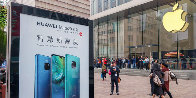 שלט של וואווי מול חנות של אפל בסין, צילום: גטי אימג