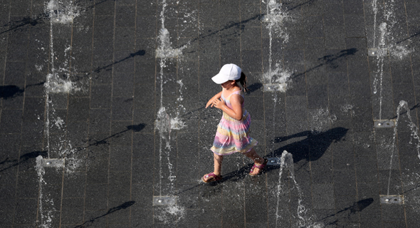 ילדה ב-Duisburg מנסה לצנן את עצמה במי המזרקות שבעיר, צילום: EPA