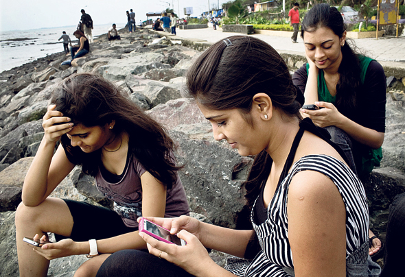 צעירות בהודו משתמשמות בסמארטפון. "זמן מסך זה דבר מגוון", צילום: בלומברג