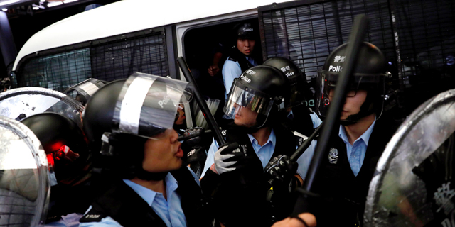 שוטרים מתעמתים עם מפגינים בשדה התעופה בהונג קונג, צילום: רויטרס