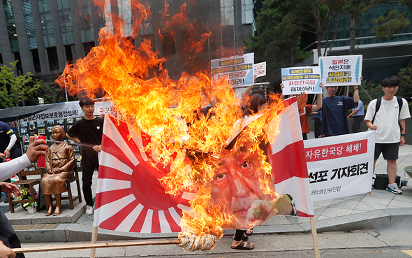 מפגינים בסיאול שורפים את דגל יפן האימפריאלית