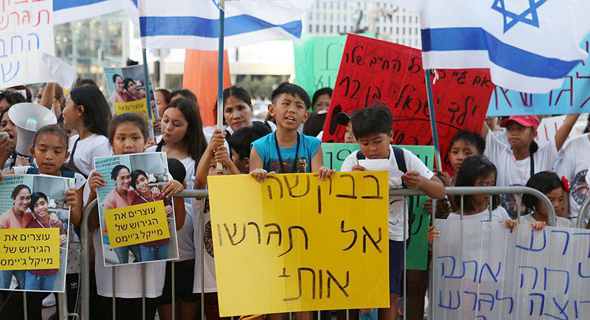 A child holding a sign saying "please don't deport me," at a demonstration in Tel Aviv earlier this month. Photo: Tommy Harpaz
