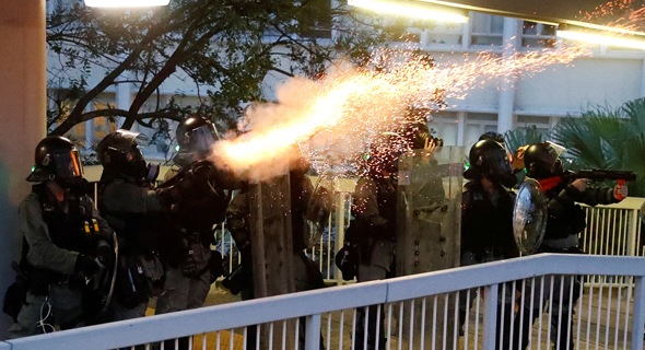 שוטרים יורים גז מדמיע בהונג קונג, צילום: Kai Pfaffenbach