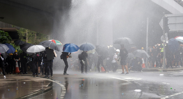 מטריות כמגן מפני זרנוקי מים, צילום: EPA