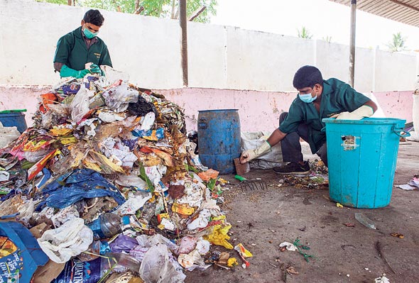 פועלים ממיינים פסולת פלסטיק ביתית, צילום: בלומברג