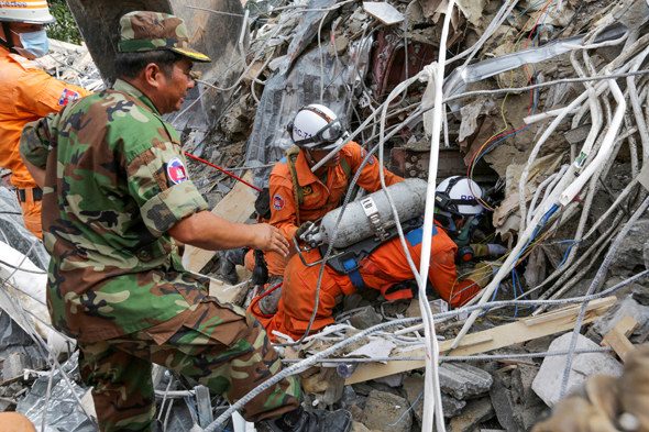 כוחות הצלה מנסים לאתר ניצולים בהריסות הבניין בן שבע הקומות שאכלס פועלים סינים עד שקרס