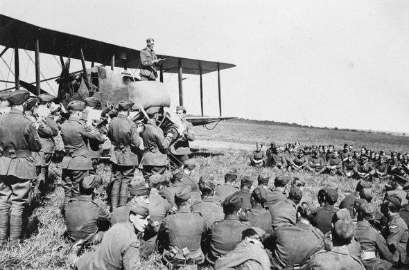 כומר צבאי נושא דרשה בפני אנשי טייסת בריטית מתא קדמי של מטוס FE2. המדחף נמצא מאחור, מתחת לכנף העליונה, צילום: IWM