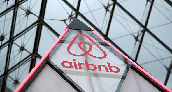 שלט של Airbnb, על הפרמידה של הלובר בפריז בחודש מרץ השנה