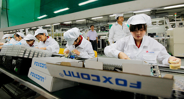 עובדי פס הייצור של פוקסקון בגואנדונג, צילום: אי פי איי