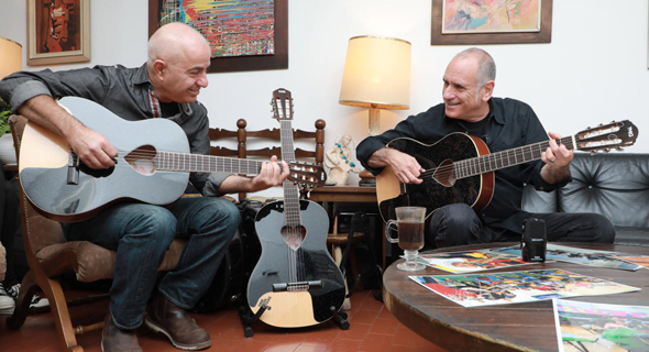 דויד ברוזה ושמוליק בודגוב עם הגיטרות שעוצבו לעמותה. “שאלו למה שלא אחלק כלי נגינה", צילום: דנה קופל