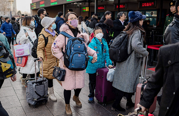 נוסעים עם מסיכות בינואר בתחנת הרכבת בבייג'ינג