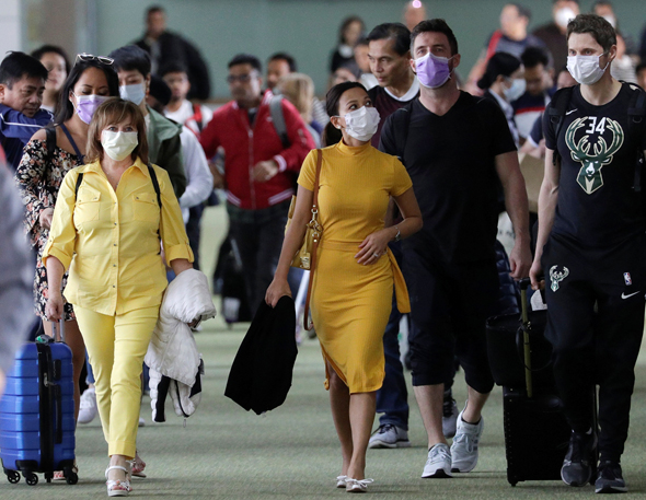 אנשים עם מסכות בנמל התעופה בפיליפינים