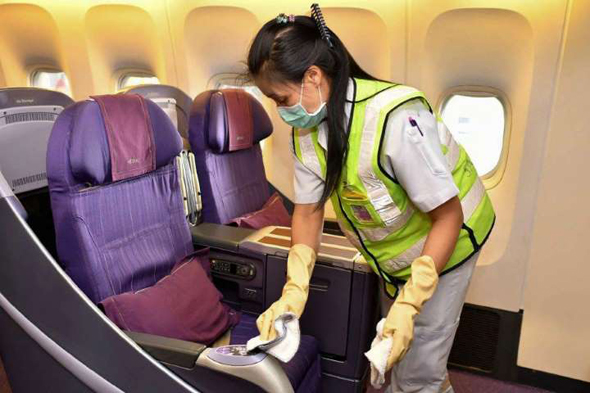 An employee sterilizes the seats on a plane. Photo: AFP