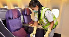 An employee sterilizes the seats on a plane. Photo: AFP