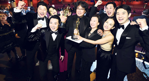 השחקנים וצוות ההפקה של “פרזיטים”, עם הבמאי בונג ג’ון־הו במרכז, אוחזים בפסלוני האוסקר. ניפצו כל סטטיסטיקה וכל תחזית מוקדמת
