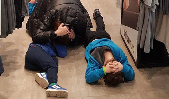 תושבים באשקלון שוכבים על הרצפה בזמן אזעקה (ארכיון)