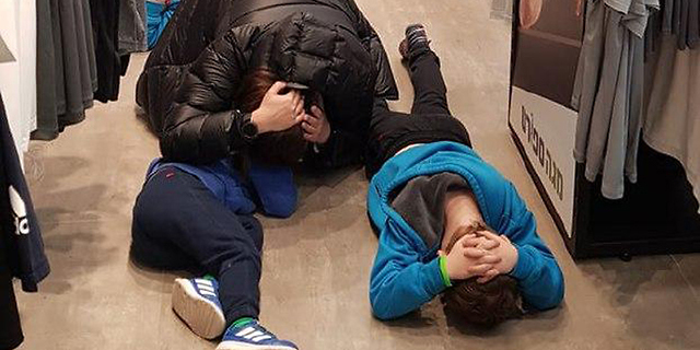 תושבים באשקלון שוכבים על הרצפה בזמן אזעקה (ארכיון), צילום: אלכס בורטמן
