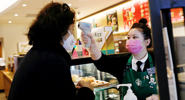 מוכרת בסניף סטארבקס בסין בודקת חום ללקוחה