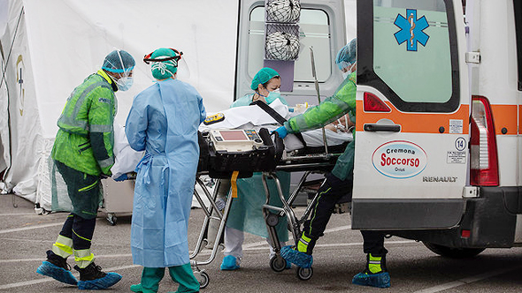 A coronavirus patient is led into an ambulance. Photo: Getty Images