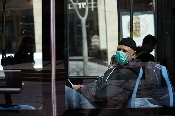 A man wearig a mask on a bus in Jerusalem. Photo: Amit Shabi