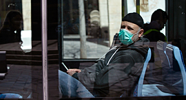 A man wearig a mask on a bus in Jerusalem. Photo: Amit Shabi