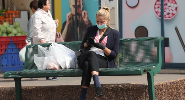 A woman wearing a mask and gloves. Photo: Gadi Kabalo