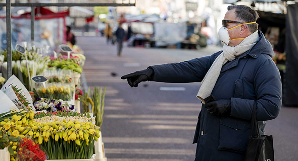 אדם רוכש פרחים בשוק הפרחים באמסטרדם הולנד , צילום: אי פי איי