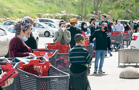 Shoppers line up outside a supermarket in March 2020. Photo: Amit Shabi