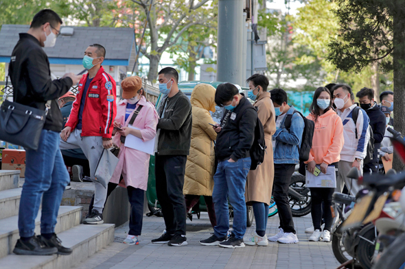 עובדים ממתינים לבדיקת חום במגדל משרדים בבייג'ינג סין 