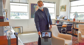 Erel Margalit hands a form to a robot for contactless delivery