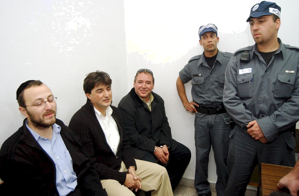 יושבים מימין: אמסלם עם חברי הקבוצה הירושלמית יורם קארשי ויצחק קויפמן בעת מעצרם ב־2003 בחשד לזיוף מסמכים כדי לגייס מתפקדים חדשים לליכוד