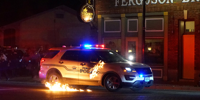 מכונית משטרה עולה באש במיניסוטה, צילום: רויטרס