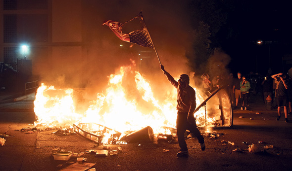 A protester burns the U.S. flag during a rally in St. Louis. Photo: Reuters