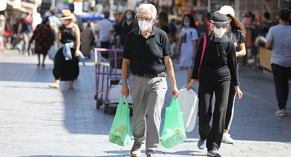 People wearing face masks in Jerusalem. Photo: Alex Kolomoisky‎
