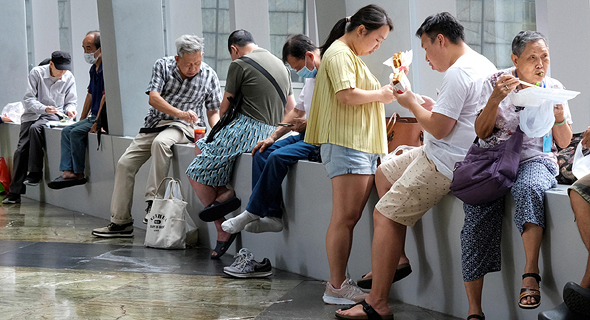 עובדים בהונג קונג אוכלים על המדרכות לאחר שהמסעדות נסגרו לישיבה, צילום: רויטרס