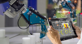 An operator controlls a robot in a factory. Photo: Shutterstock