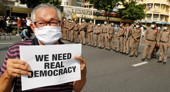 מפגין נושא שלט ועליו הכיתוב - "אנחנו זקוקים לדמוקרטיה אמיתית", צילום: רויטרס