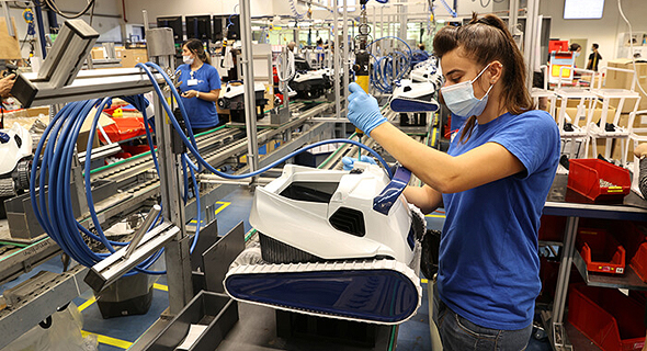 A factory worker constructs Maytronics