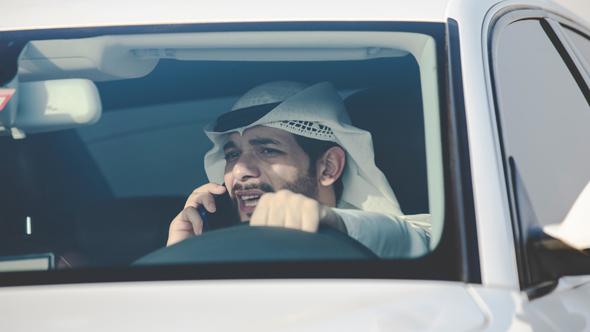 אדם מדבר בסלולרי ברכב, איחוד האמירויות, צילום: שאטרסטוק