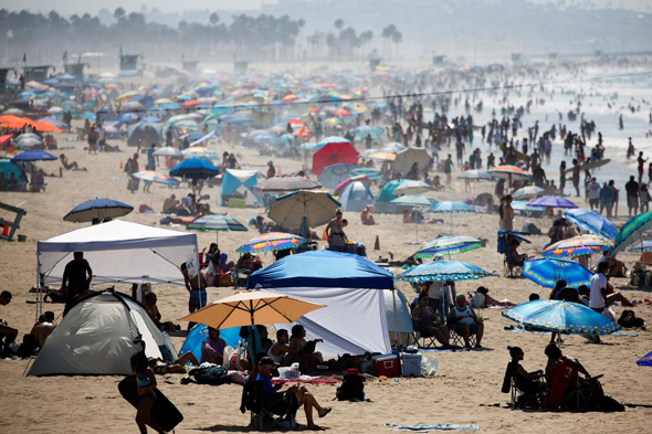 אנשים בחוף סנטה מוניקה בקליפורניה ביום ראשון האחרון, צילום: רויטרס