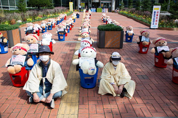 מחאת האיגודים המקצועיים בדרום קוריאה. לבושים בבגדי אבל בגלל הסגר, צילום: EPA