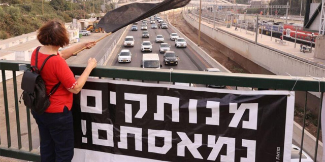 מפגינה בגשר השלום, צילום: מוטי קמחי